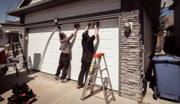 Expert technician replacing old garage door with modern design in Tallahassee.