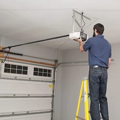 Specialist repairing garage door opener system in Tallahassee residence.